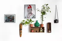 Two paintings on a wall: a portrait and a family of six on a motorbike